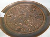 une assiette marron ornée d'un motif, posée sur une table