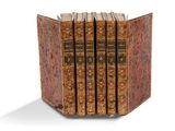 trois livres sont empilés sur une surface blanche