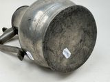 a metal cup with a handle on a white surface