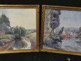 two framed paintings of a river scene with houses and trees