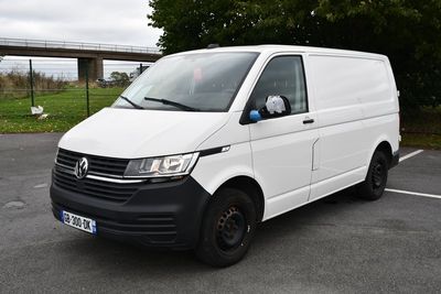 La camionnette blanche est garée sur le parking à côté d'un pont.