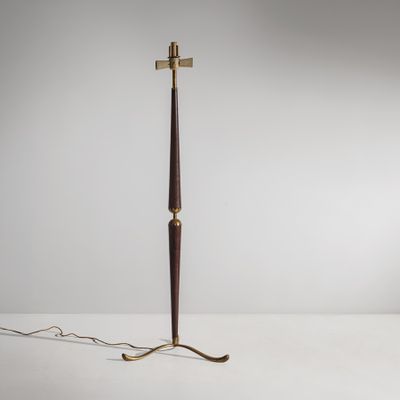 un grand lampadaire en laiton et en bois, muni d'un abat-jour noir