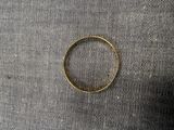 un gros plan d'une bague en or posée sur un tissu noir