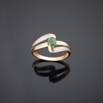 une bague en or sertie d'une émeraude et de diamants