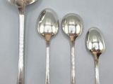 four spoons and a spoon rest on a white surface