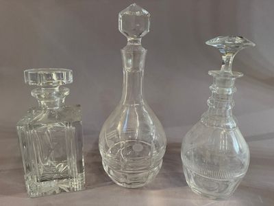 three glass bottles that are sitting next to each other on a table