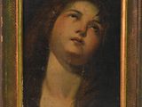une peinture à l'huile représentant le visage d'une femme, dans un cadre doré