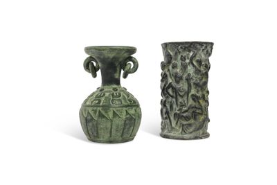 two green vases sitting next to each other on a white surface