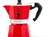 une cafetière rouge posée sur une table blanche