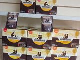 Plusieurs boîtes de café sont posées sur une étagère dans une pièce