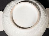 a white bowl on a black table with a black background