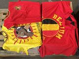 deux t-shirts rouges et jaunes posés sur une palette à côté d'une poubelle