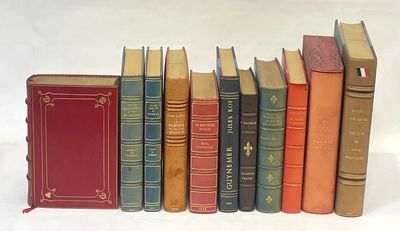 several old books are lined up in a row on a white surface