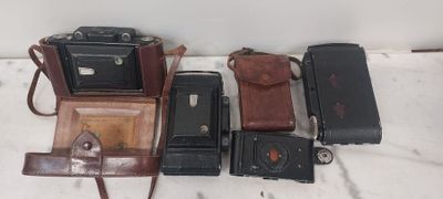 un tas de vieux appareils photo posés sur une table