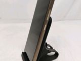 a close up of a cell phone on a stand on a white surface