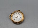 une petite montre de poche en or avec des chiffres romains