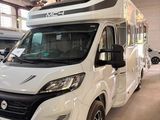 un camping-car blanc garé dans un garage avec d'autres véhicules