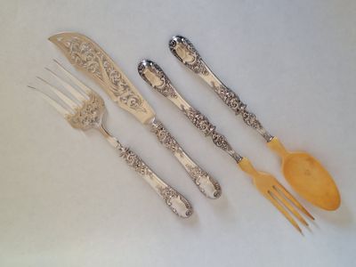 four forks and two spoons on a white table