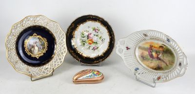 Trois assiettes et une boîte en forme de cœur sont posées sur une table