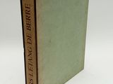 an old book sitting on top of a white table next to a white wall
