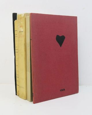 trois livres sont empilés les uns sur les autres, avec un cœur découpé dans chacun d'eux