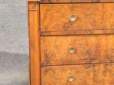 a small wooden chest of drawers with a marble top