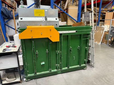 une armoire verte au milieu d'un entrepôt rempli de cartons