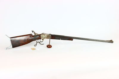 un vieux pistolet avec un canon en bois et une poignée en métal