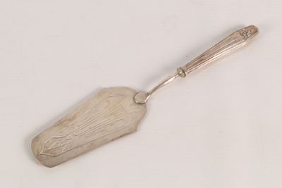 a silver spoon with a handle on a white surface
