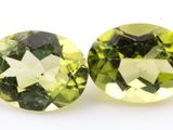 a pair of two green and white gems on a white surface