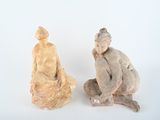 two figurines of a man and a woman sitting next to each other