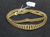 a close up of a gold chain bracelet on a black surface