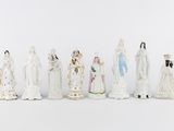many figurines of people dressed in white and gold