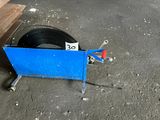 a tire on the ground next to a blue cart