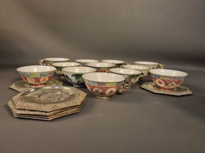 Plusieurs tasses et soucoupes sont alignées sur une table