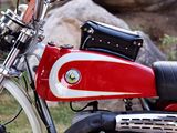 a red and white motorcycle parked in front of a rock