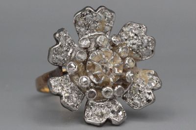 une image d'une bague orné d'une fleur en diamant sur fond gris