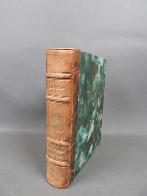 an old book sitting on top of a table next to a gray background