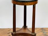 an old wooden table with a marble top sitting on a wooden floor