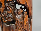 a wooden cup with carvings of people and animals on it