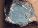 a blue bib in a box that is wrapped in plastic
