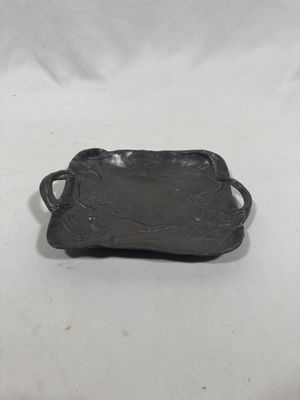 an antique cast iron tray with handles on a white background