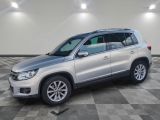 une Volkswagen Tiguan argentée garée dans une pièce au sol à carreaux