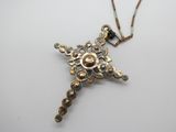 une image représentant un collier orné d'une croix, posé sur un fond blanc