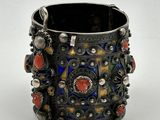 un gros plan sur un bracelet en argent orné de pierres colorées
