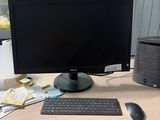 a computer desk with a monitor, keyboard, mouse and speaker