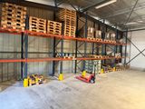 un grand entrepôt rempli d'une multitude de palettes et de cartons