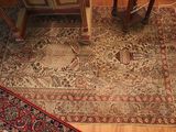 a rug on the floor next to a table and a chair