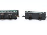 four miniature trains are lined up on a white surface