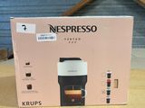 une boîte posée sur une table, sur laquelle se trouve une cafetière
